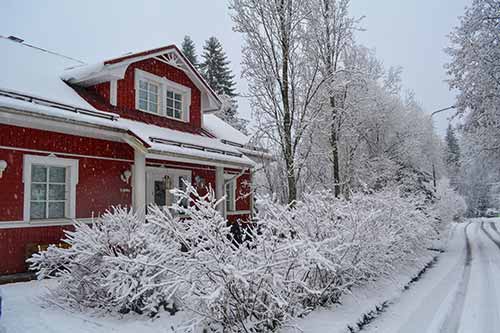 Rotes Holzhaus im Schnee im Winter